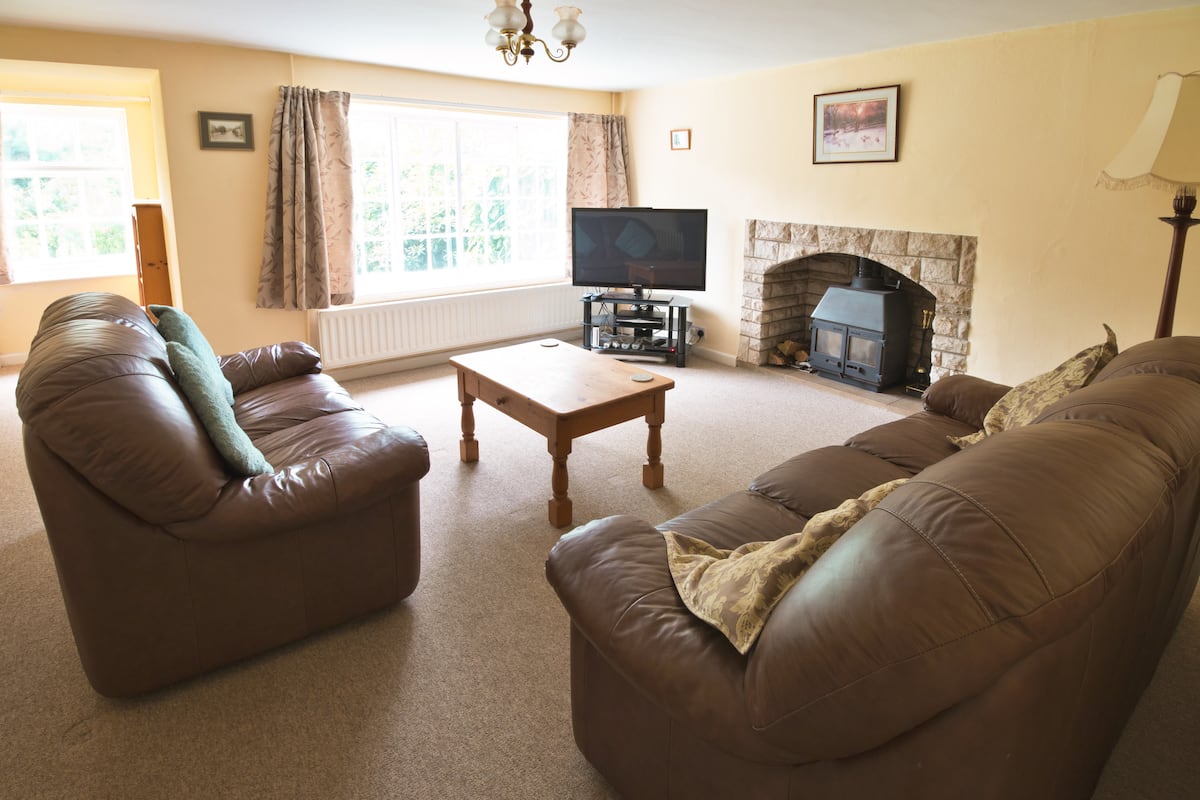 Cosy living room at Apple Cottage with wood-burning log burner, a dog-friendly Dorset holiday cottage